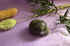 Green Fluorite crystal skull carving back view on lilac background — The Crooked Moon