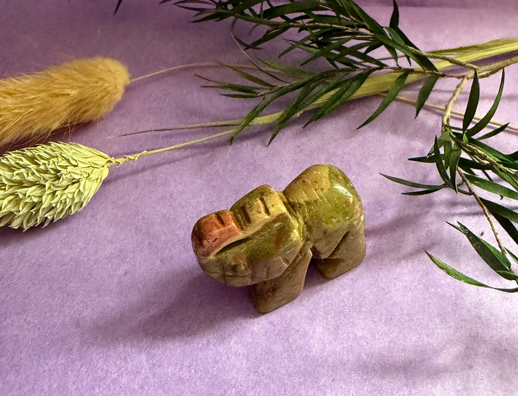 Unakite crystal elephant carving side view on purple background with dried botanicals — The Crooked Moon