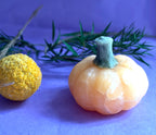 Orange Calcite crystal pumpkin carving with Green Aventurine stem on lilac background — The Crooked Moon