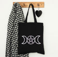 Triple Moon tote bag styled hanging on wall hook