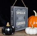 Spells and Curses hanging sign styled with Halloween pumpkins on dark background
