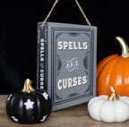 Spells and Curses hanging sign styled with Halloween pumpkins on dark background