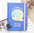 Moon Dream Journal styled flat lay with amethyst crystal moon and dried flowers