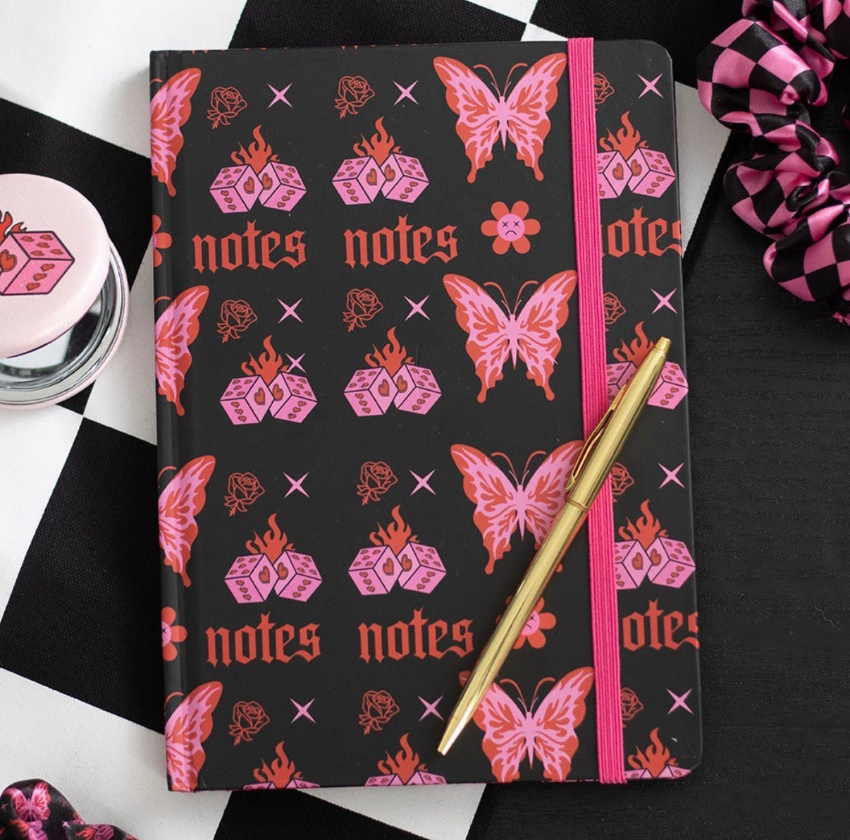 Flaming Butterfly A5 Notebook lifestyle flat lay with pen on checkered background