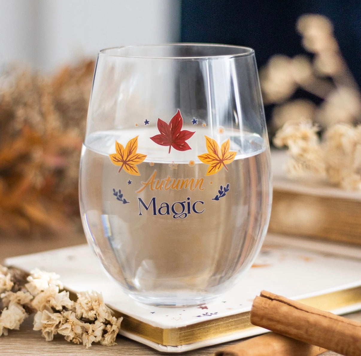 Autumn Magic Stemless Wine Glass lifestyle shot on wooden surface with dried flowers