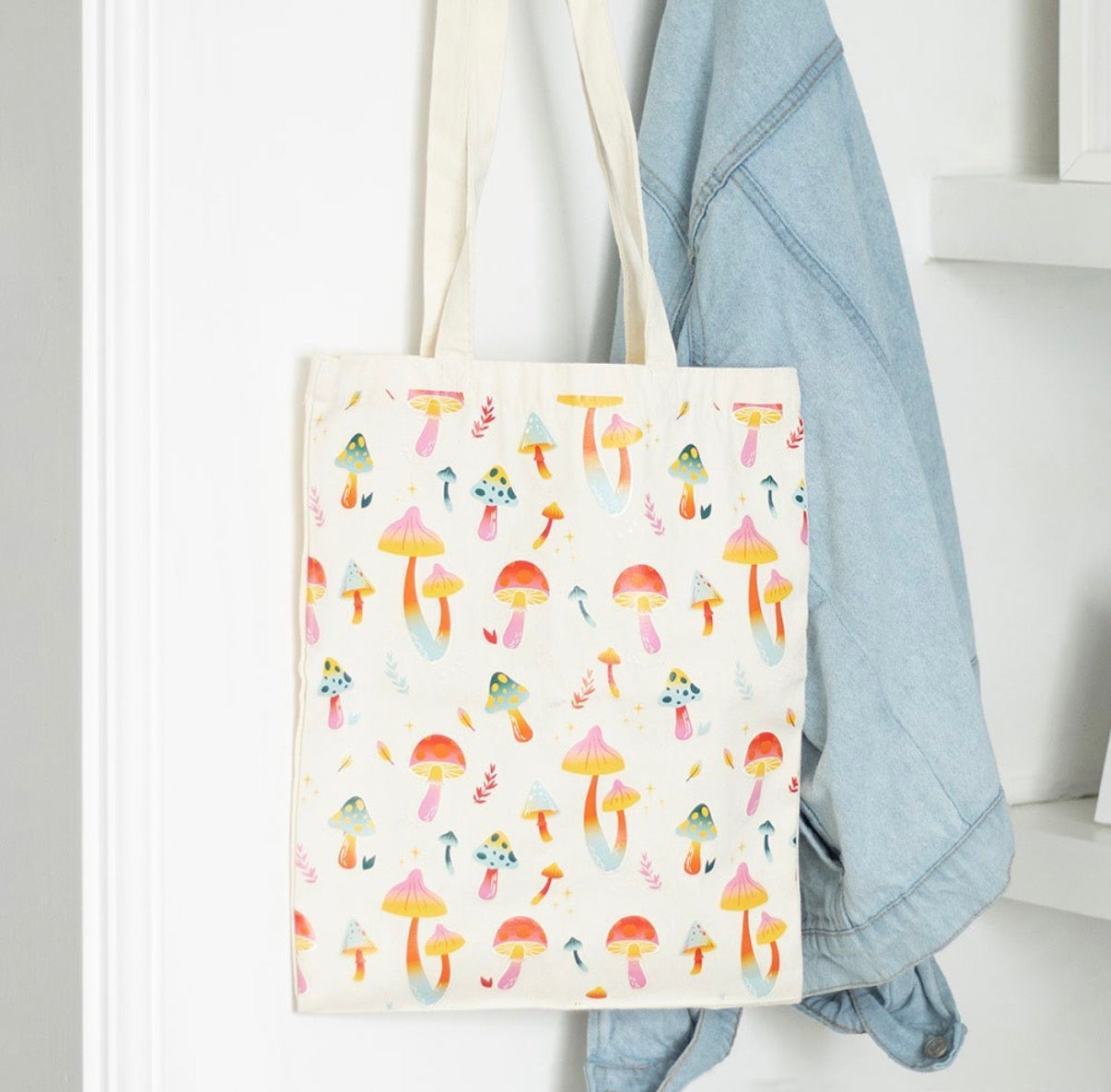 Funky Fungi Mushroom Print Tote Bag lifestyle shot hanging on hook with denim jacket