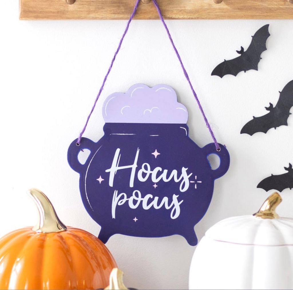 Hocus Pocus Cauldron Hanging Sign lifestyle shot on wall with pumpkins and bats