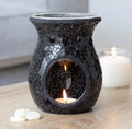 Black Crackle Mosaic Glass Oil Burner lifestyle shot lit with tealight on wooden surface with white candles