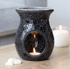 Black Crackle Mosaic Glass Oil Burner lifestyle shot lit with tealight on wooden surface with white candles