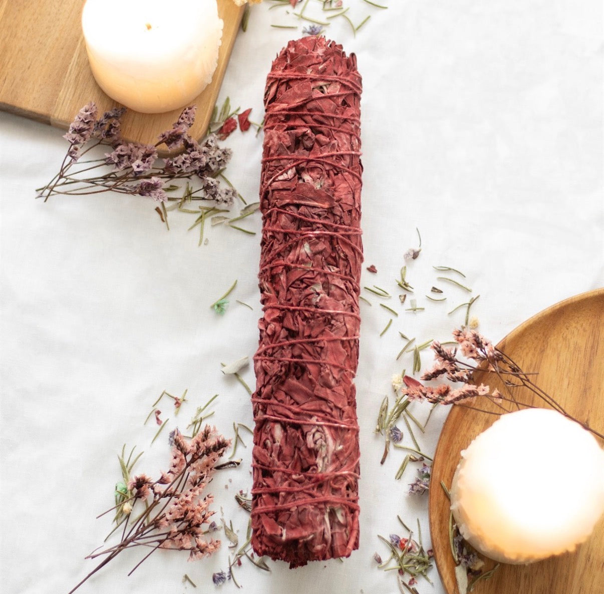 Dragon's Blood Sage Wand lifestyle flat lay on white linen with dried flowers and candles