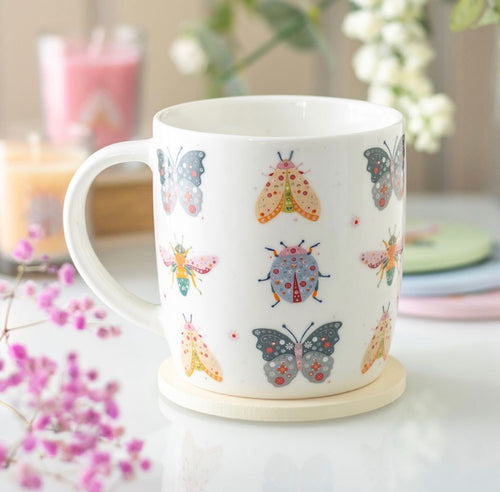 Butterfly and Bug Garden Ceramic Mug - lifestyle shot with flowers