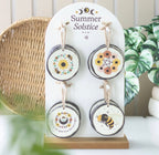 Summer Solstice Wood Slice Hanging Ornaments - lifestyle shot on display stand showing all 4 designs