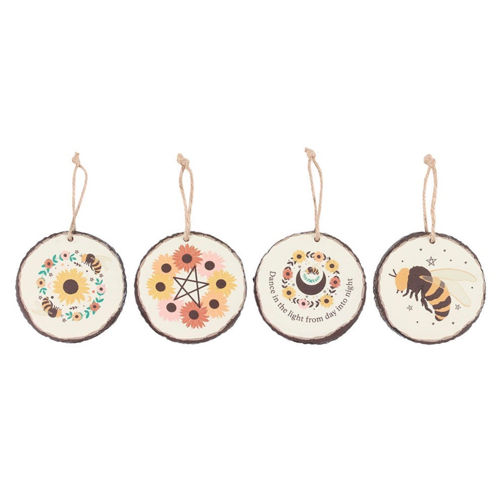 Summer Solstice Wood Slice Hanging Ornaments - all 4 designs flat lay on white background: Bee Wreath, Sunflower Pentagram, Moon & Flowers, Bumble Bee