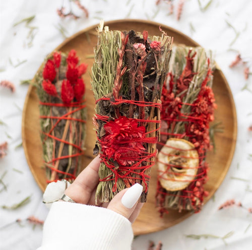 Luxury Ritual Wand Smudge Stick - lifestyle shot being held over wooden board with other variants