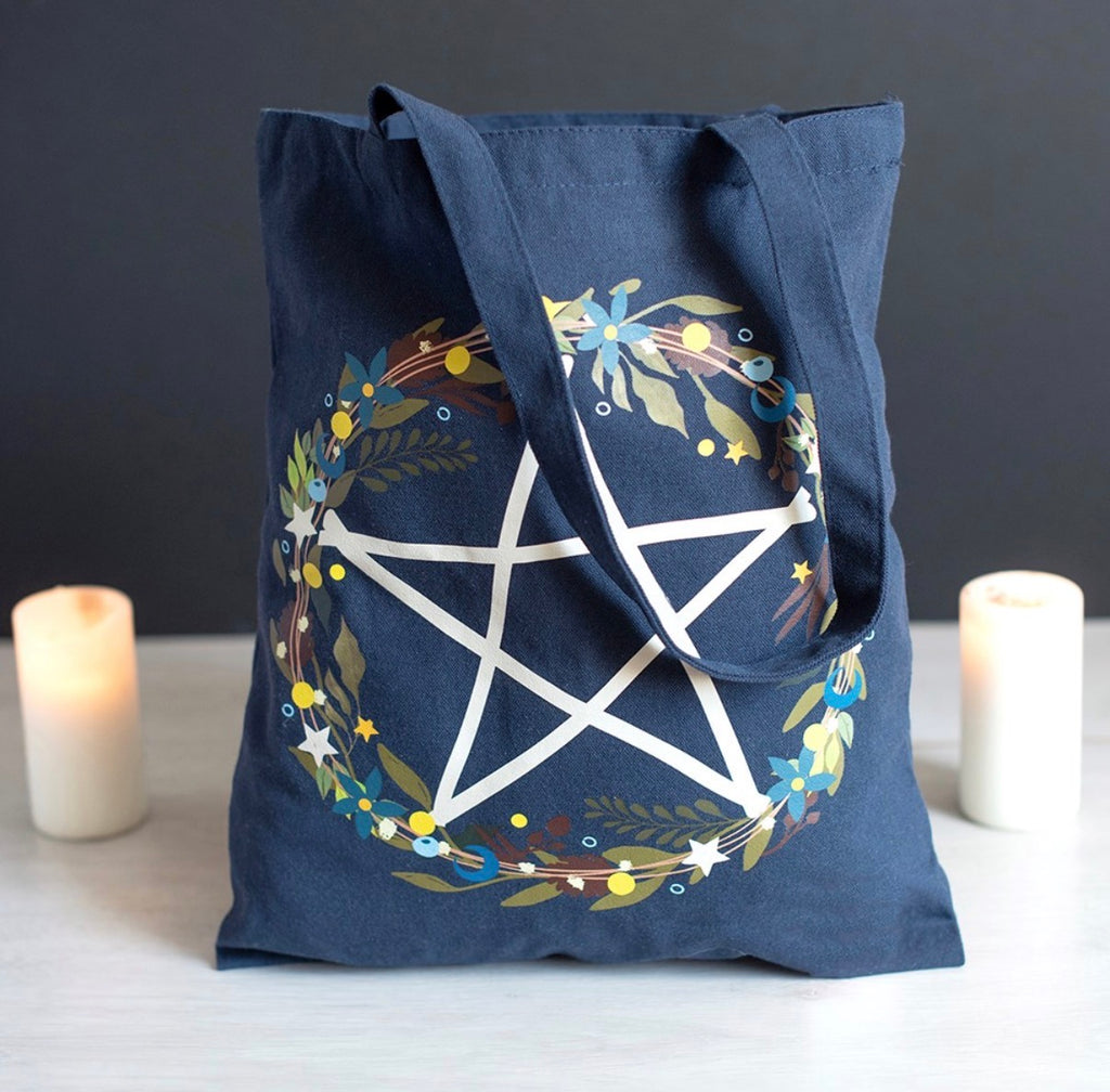 Solstice Wreath Tote Bag lifestyle shot with candles showing pentagram wreath print