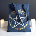 Solstice Wreath Tote Bag lifestyle shot with candles showing pentagram wreath print