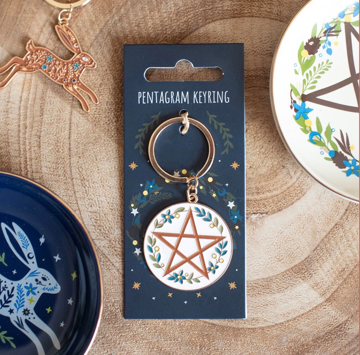Solstice Wreath Keyring lifestyle shot on wooden surface with trinket dishes