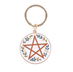Solstice Wreath Keyring close up showing pentagram and floral wreath enamel detail white background
