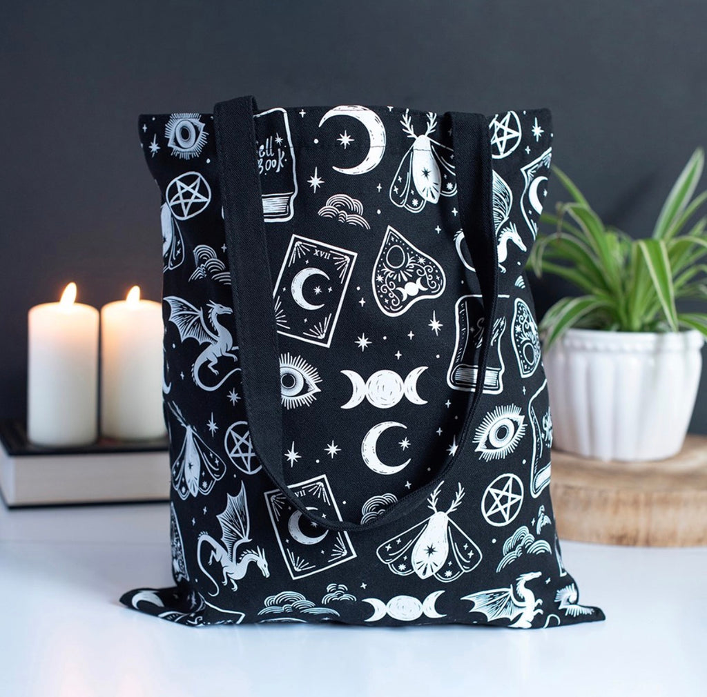 Witchy Icons Tote Bag lifestyle shot with candles and plant showing all-over print