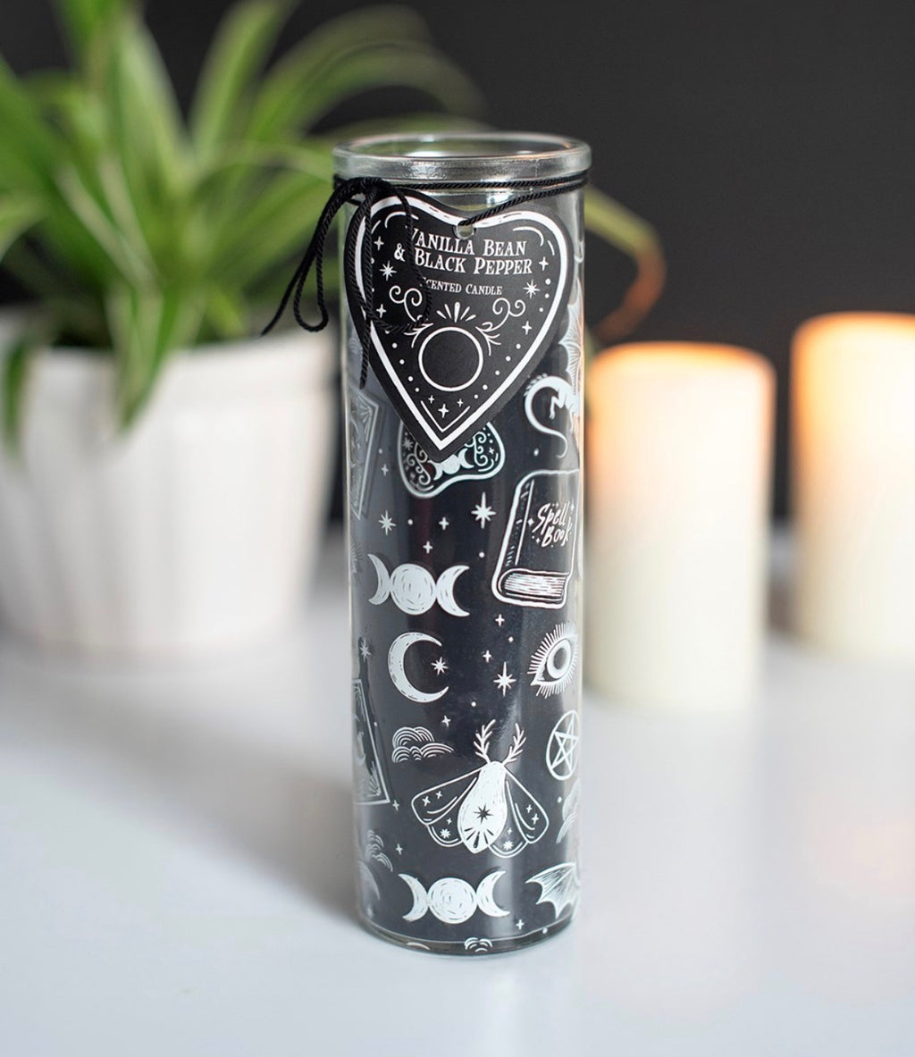 Spellbound Secrets Vanilla Bean and Black Pepper Scented Candle lifestyle shot with plants and candles