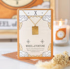 Wheel of Fortune tarot necklace on illustrated backing card - styled shot