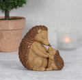 Hedgehog and hoglet figurine lifestyle shot with plant pot and candle in background