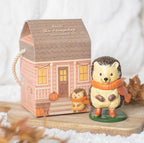 Hazel The Hedgehog resin ornament beside cottage house gift box on wooden board with autumn styling