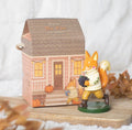 Flynn The Fox resin ornament with autumn cottage gift box on wooden board with dried leaves