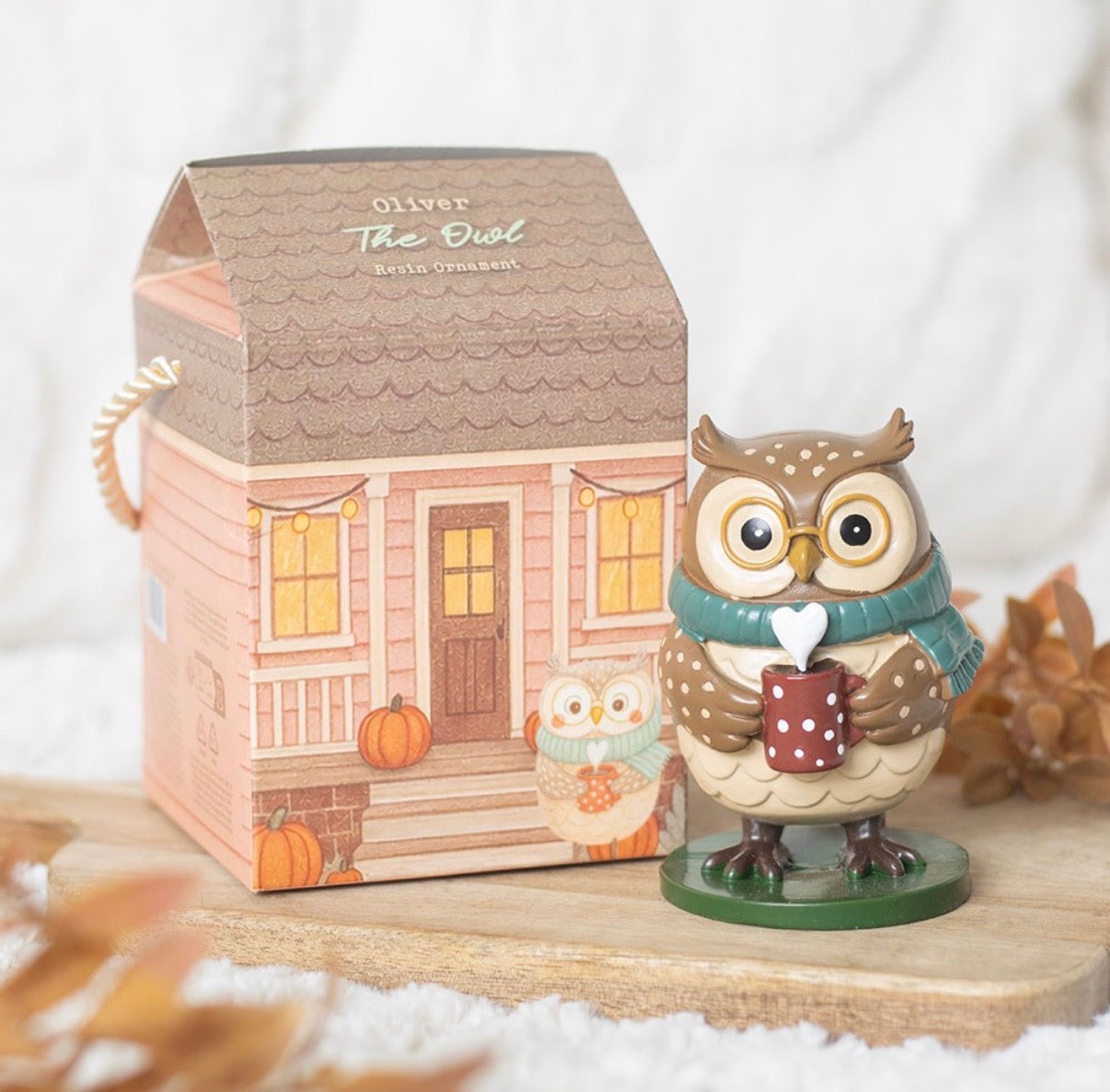 Oliver The Owl resin ornament with cottage gift box on wooden board with autumn leaves