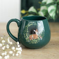 Enchanted Forest Fawn Mug in deep forest green with moonlit fawn and botanical wreath design, styled with baby's breath flowers