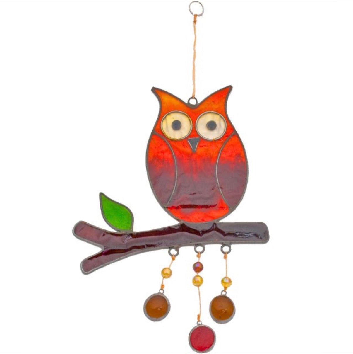 Stained glass style orange red owl suncatcher perched on a branch with green leaf and amber glass drop pendants, white background product shot