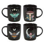 Set of four individual black ceramic Dark Forest mugs laid out on white background showing all four designs: luna moth, forest mushrooms, celestial bee, moon mushroom