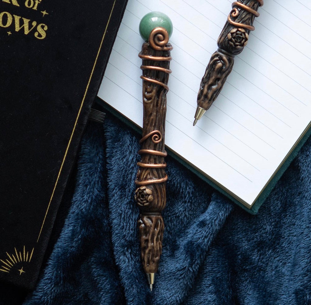 Green Aventurine Abundance Wand shown as a pen alongside a Book of Shadows journal on blue velvet
