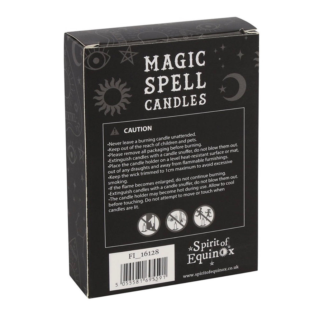 Hand holding a box of black Protection spell candles beside lit candles and dried flowers