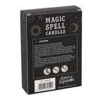Hand holding a box of black Protection spell candles beside lit candles and dried flowers