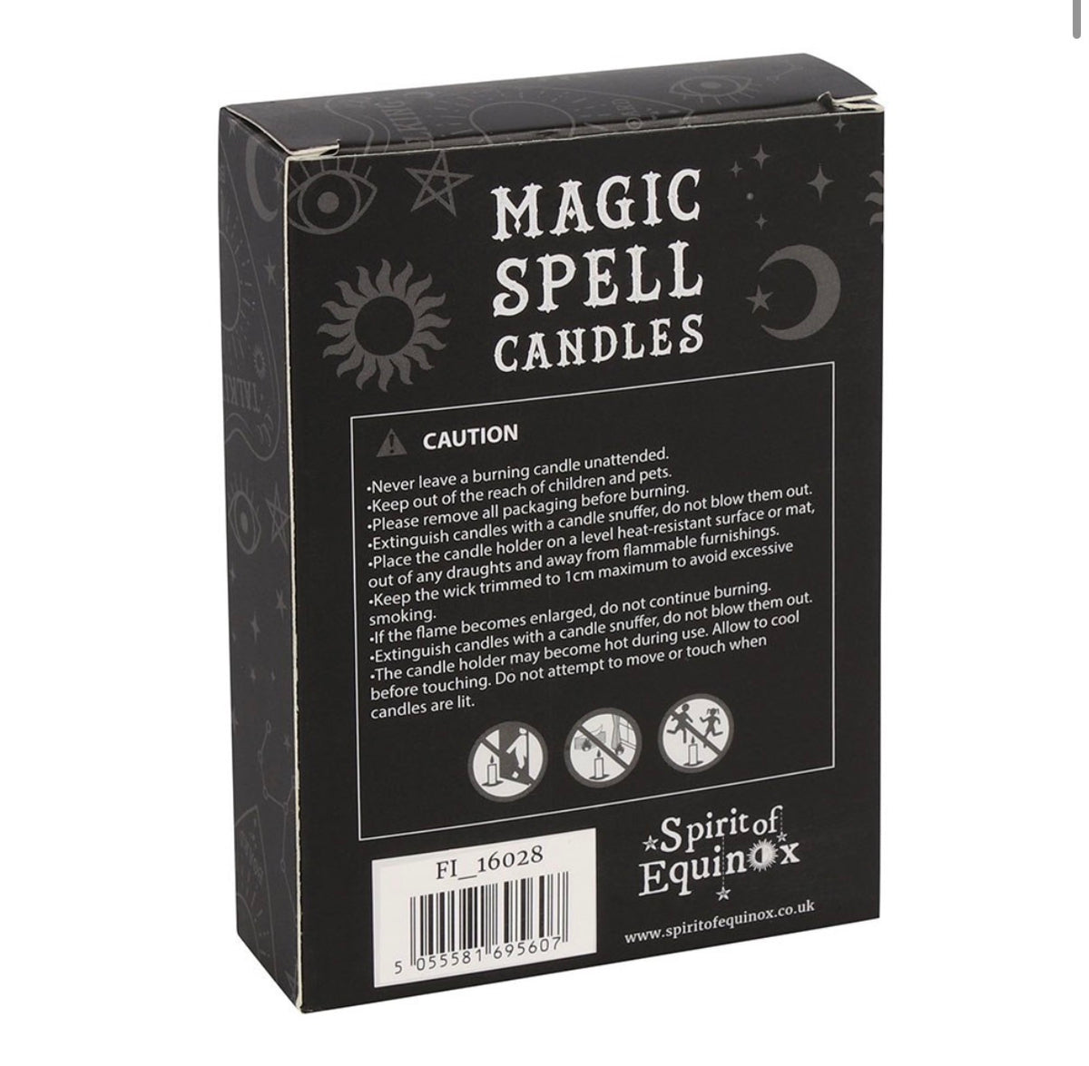 Hand holding a box of white Happiness spell candles beside lit candles and dried flowers