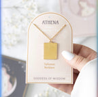 Close-up of the gold Athena pendant showing the etched goddess figure