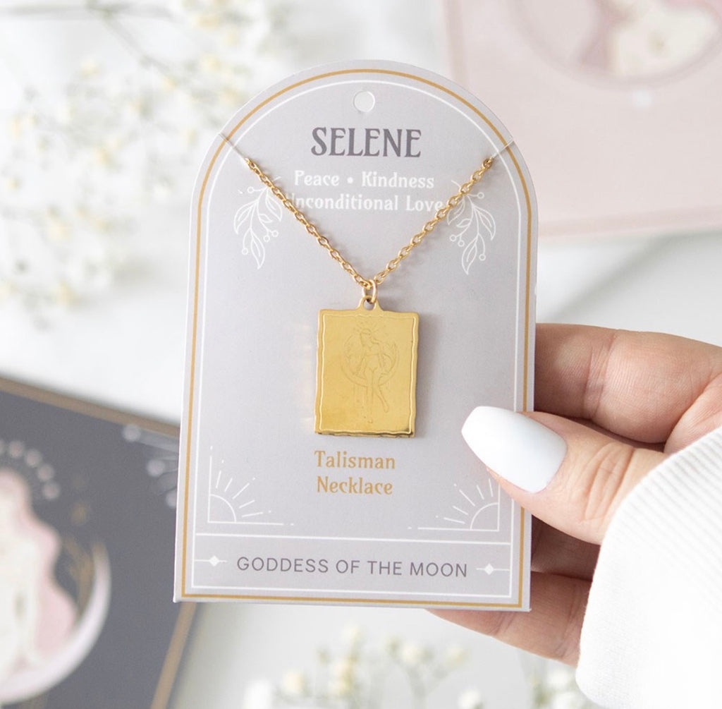 Hand holding the Selene Talisman Necklace on its Goddess of the Moon presentation card