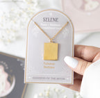 Hand holding the Selene Talisman Necklace on its Goddess of the Moon presentation card