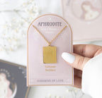 Hand holding the Aphrodite Talisman Necklace on its pink presentation card