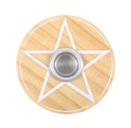 Lit white spell candle in the wooden pentagram holder, styled with dried flowers