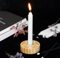 Wooden pentagram candle holder with a white spell candle in place