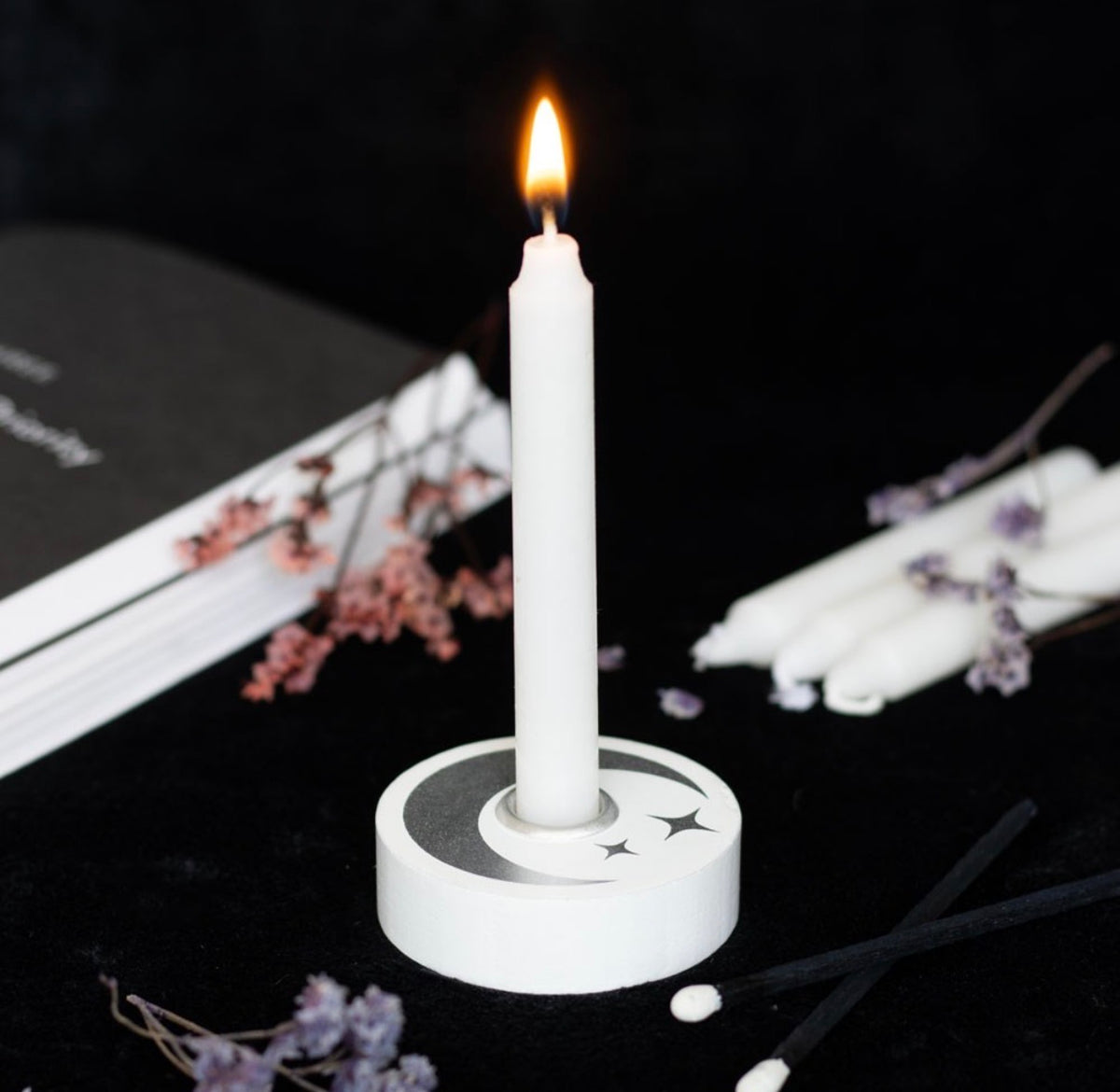 White and silver moon candle holder with a white spell candle in place