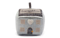 Grey fabric house doorstop with an embroidered home sweet home sign, tweed roof, pom-pom trim and stitched windows