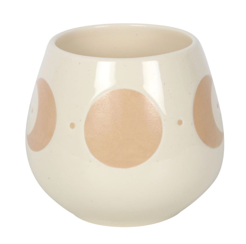 Cream moon phase ceramic mug with the handle to the right, showing crescent moons and stars
