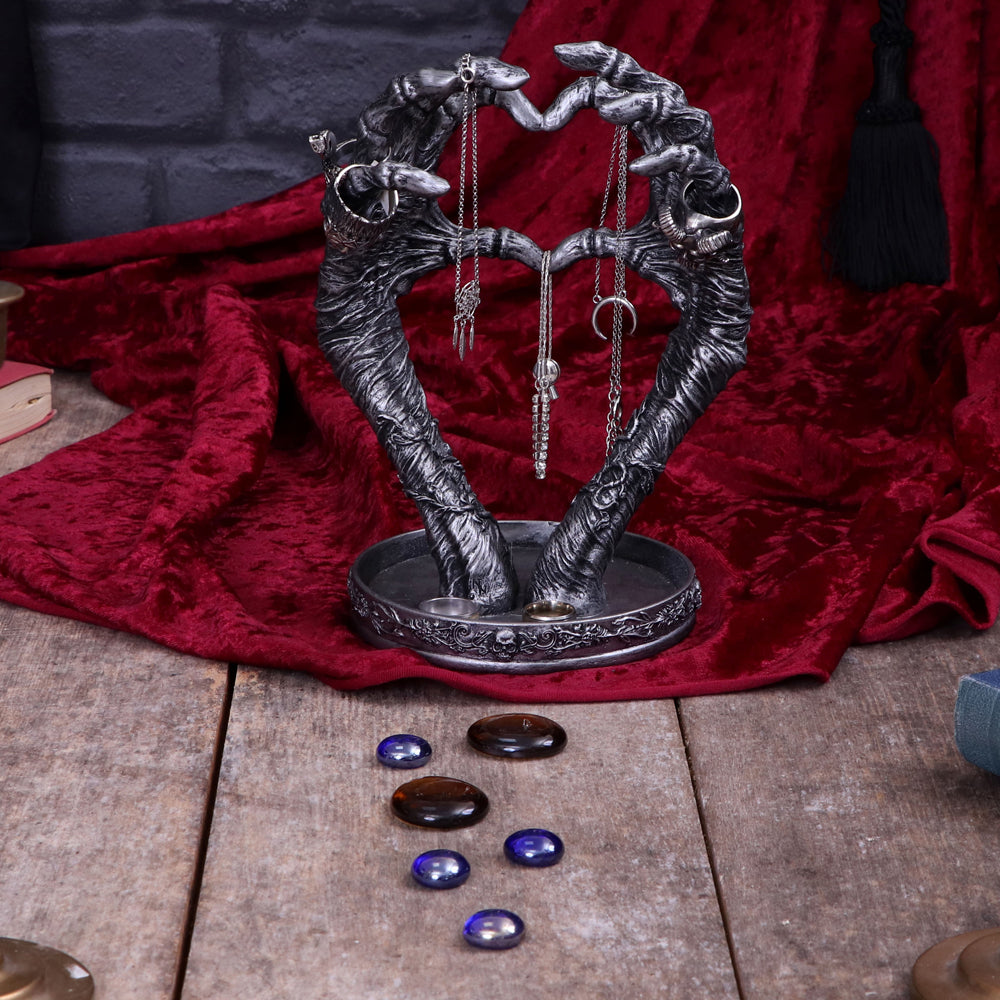 Skeleton hands heart jewellery stand - lifestyle with crystals
