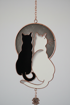 Close up detail of yin yang black and white cat topper on wind chime