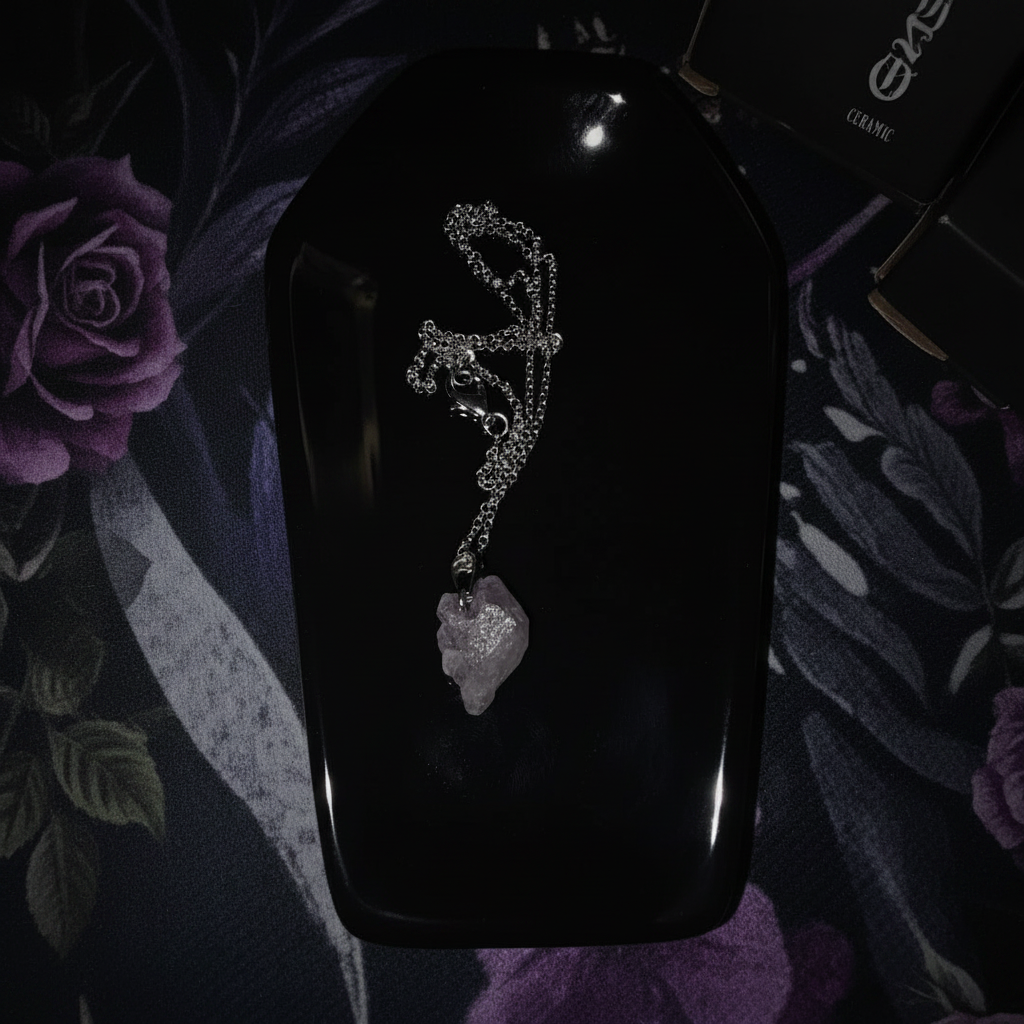 Black coffin trinket dish overhead with amethyst crystal pendant