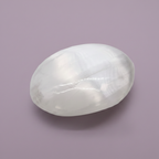 Selenite Palm Stone - plain, purple background