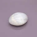 Selenite Palm Stone - surface, purple background